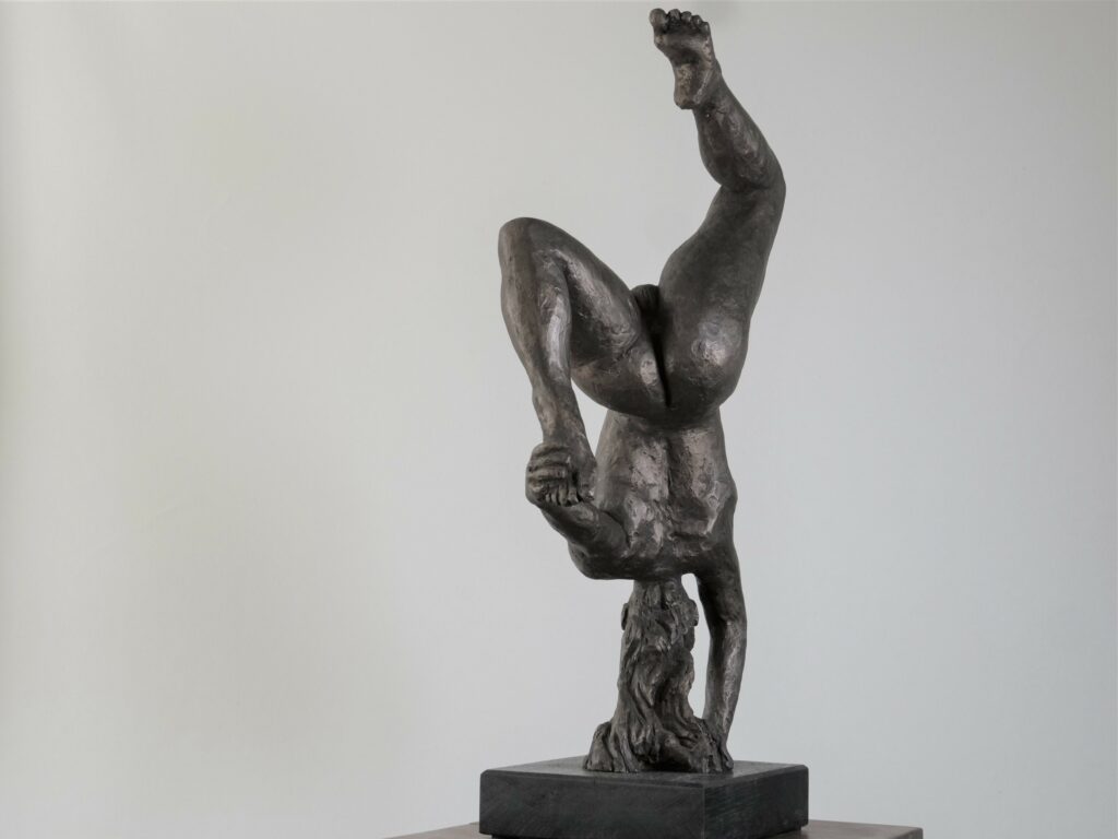 Sculpture en bronze représentant un acrobate en équilibre sur une main, corps tendu avec des lignes élancées et fluides, symbolisant la légèreté et la grâce dans un mouvement dynamique, par Jean-Pierre Picheny